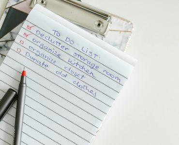 A neatly written to-do list on lined paper with a pen, perfect for organizing tasks.